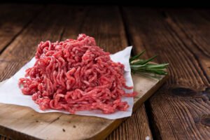 Minced Meat (close-up shot) on vintage wooden background